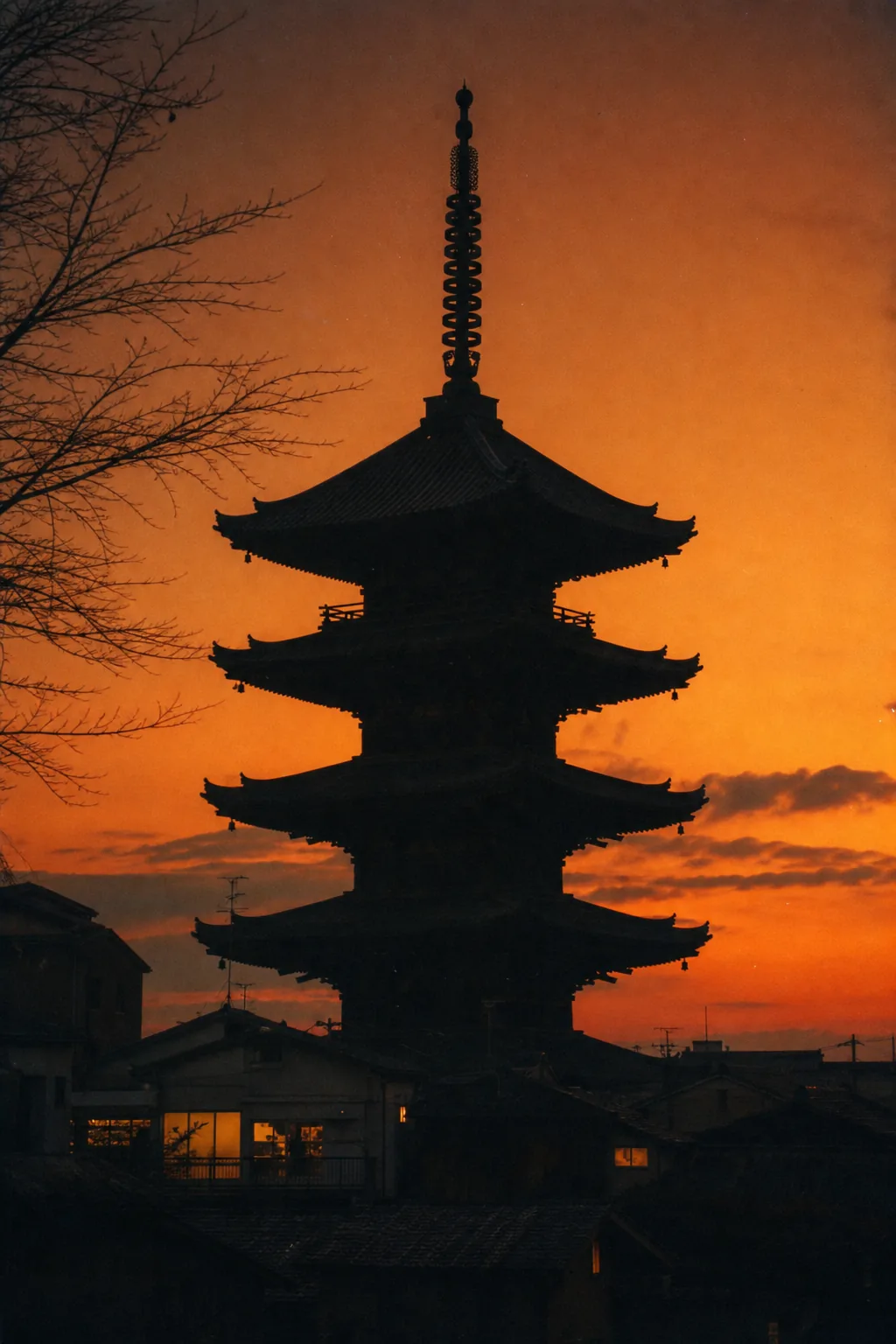 A five-storey pagoda silhouetted against an orange dusk sky